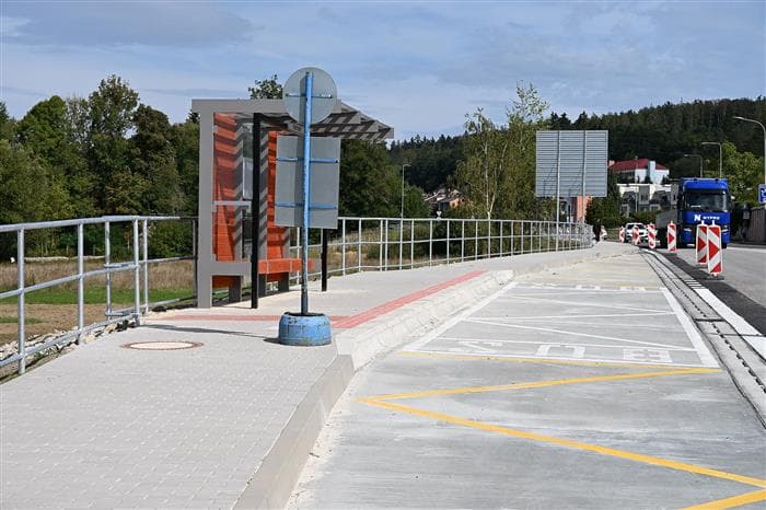 Nový dlážděný chodník se zábradlím podél silnice v Obchodní ulici v Písku, vedle něj autobusový záliv se žlutým značením a přístřešek zastávky